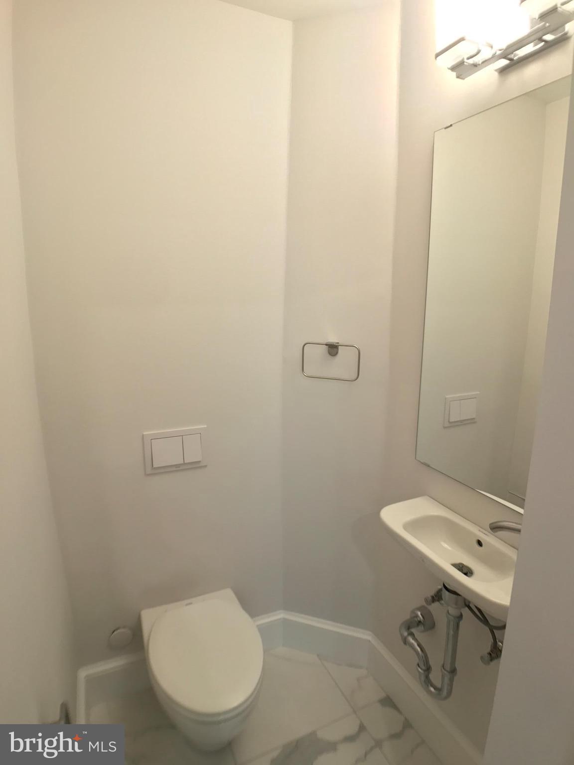 3959 Cloverhill Road Baltimore, MD 21218 - Photo 10 of 27 a bathroom with a toilet a sink and mirror