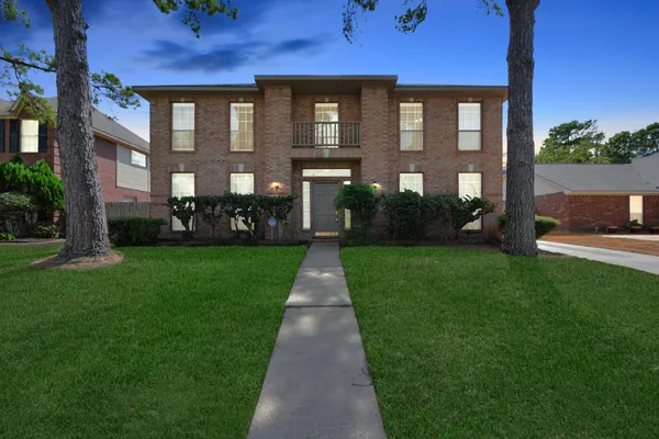 a front view of a brick house with a yard
