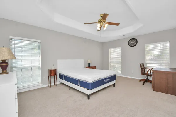a bedroom with a large bed and ceiling fan