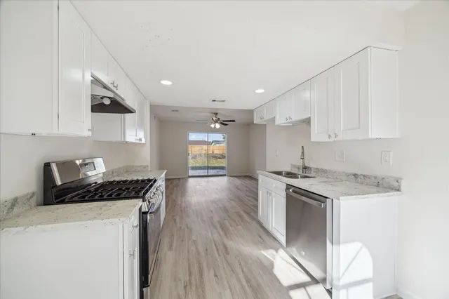 a kitchen with stainless steel appliances granite countertop a stove a sink and a refrigerator