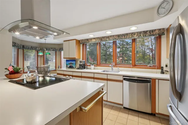 a kitchen with furniture a large window and stainless steel appliances