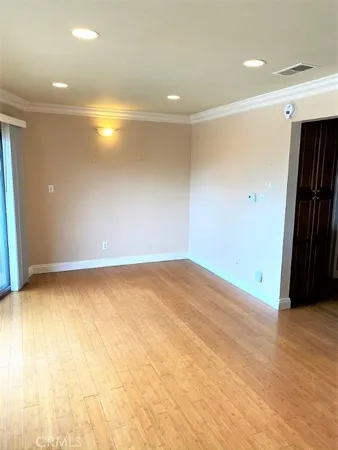 an empty room with wooden floor and entrance