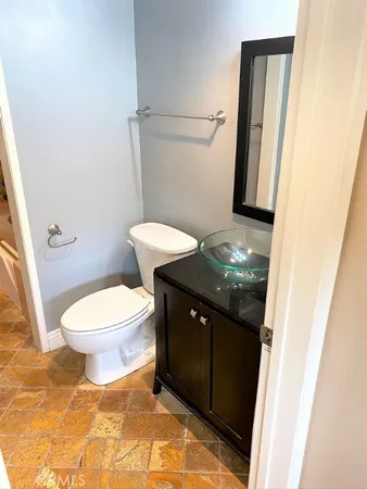 a bathroom with a granite countertop toilet and a sink