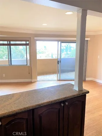 a kitchen with a sink a large window and a wooden floor