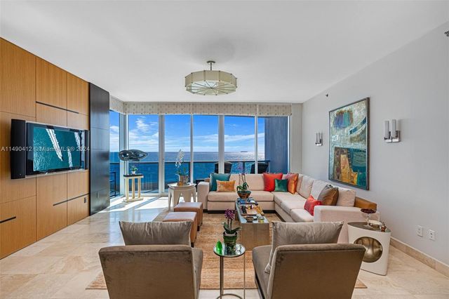 a living room with furniture a rug and kitchen view