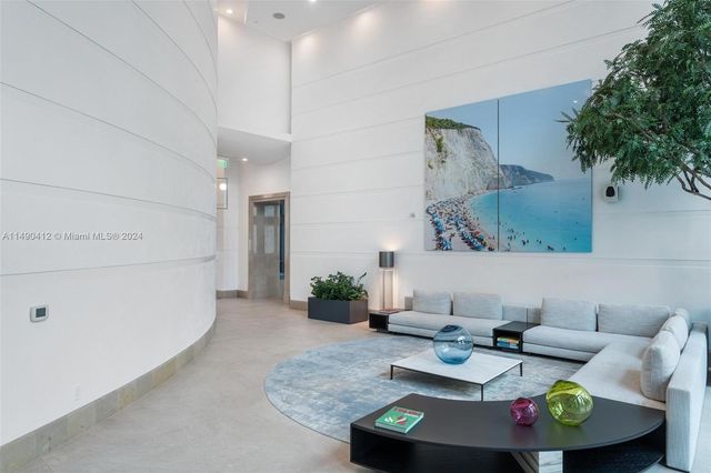 a view of a lobby with a couch and potted plants