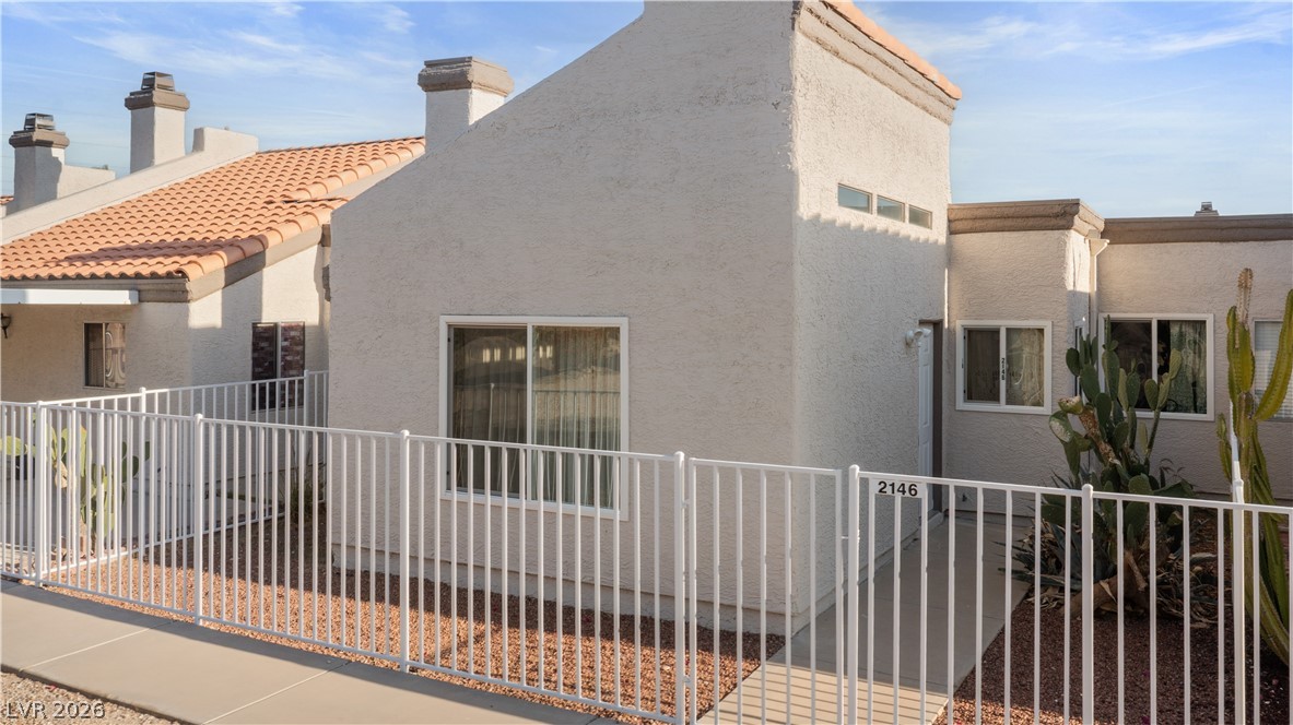 2146 High Dunes Lane Laughlin, NV 89029 - Photo 47 of 64 View of home's exterior with a chimney, a tile roof, fence, and stucco siding