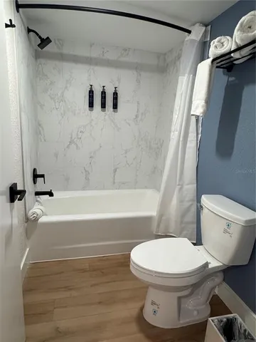 a white toilet sitting next to a bath tub