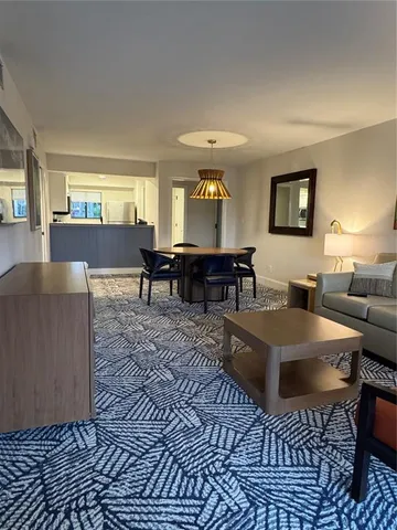 a living room with furniture a dining table and chairs with wooden floor