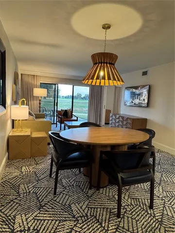 a living room with a table and a chandelier