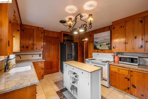 a kitchen with stainless steel appliances granite countertop a sink a stove and a refrigerator