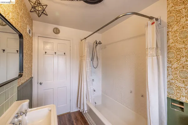 a bathroom with a tub shower vanity and a sink