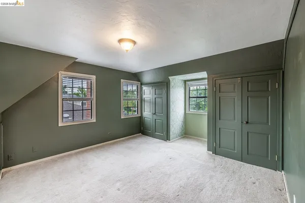 a view of an empty room with window and closet area