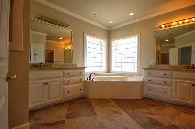 a spacious bathroom with double vanity and a mirror