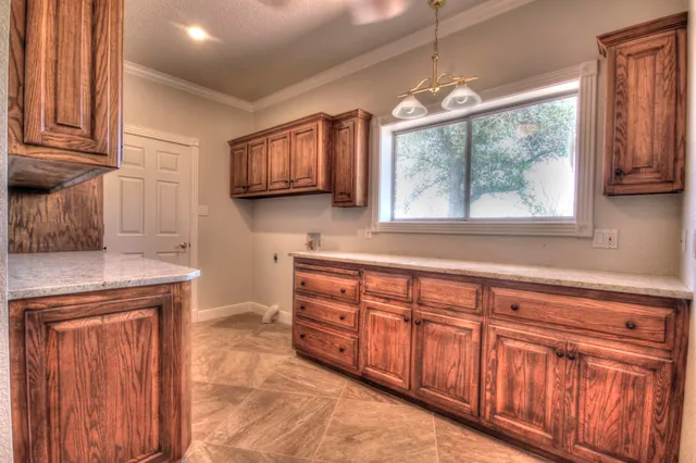 a kitchen with stainless steel appliances granite countertop wooden cabinets a stove and a window