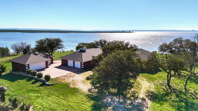aerial view of a house with a yard and lake view