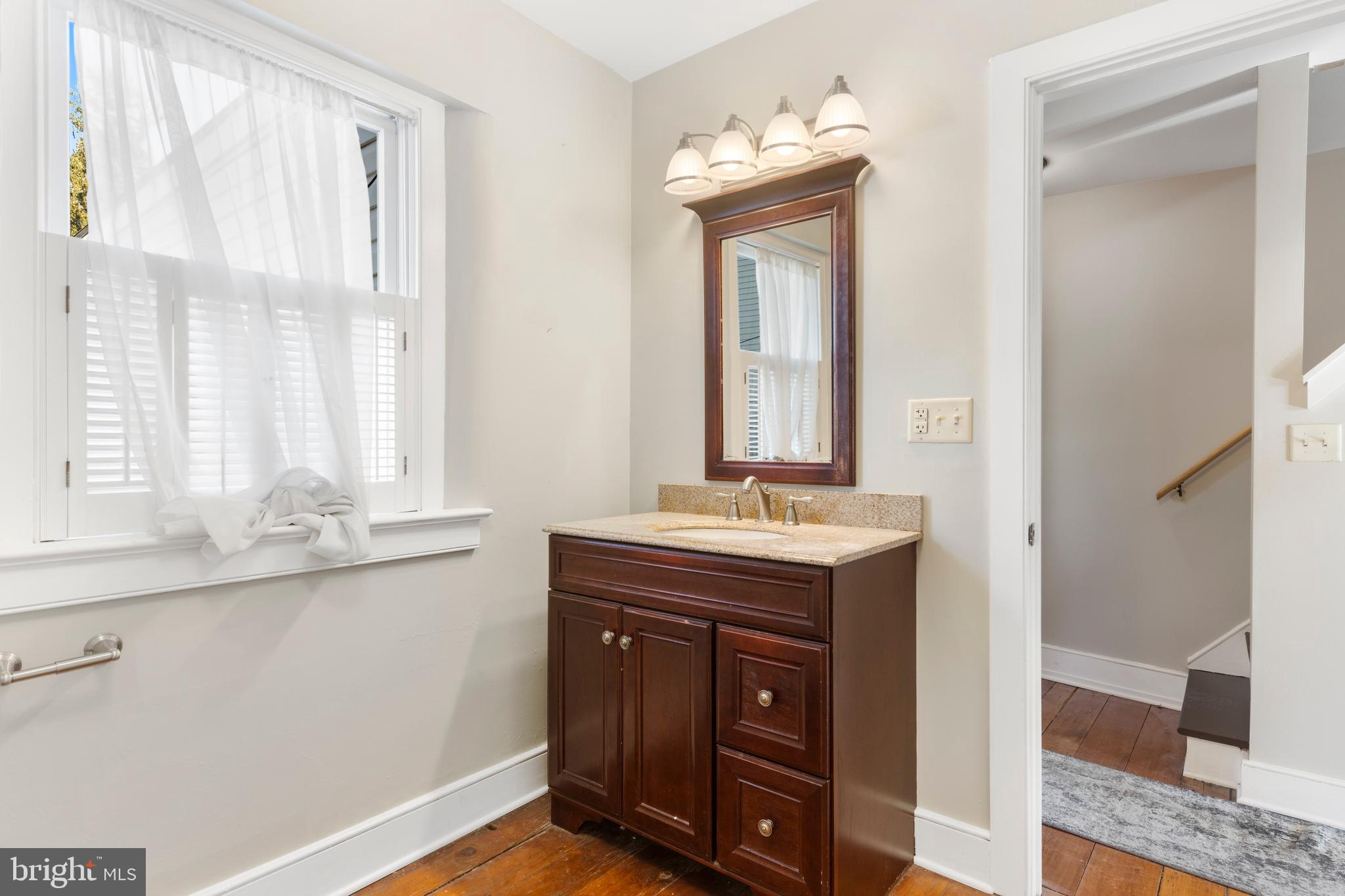 311 State Street Kennett Square, PA 19348 - Photo 31 of 37 a bathroom with a granite countertop sink and a mirror