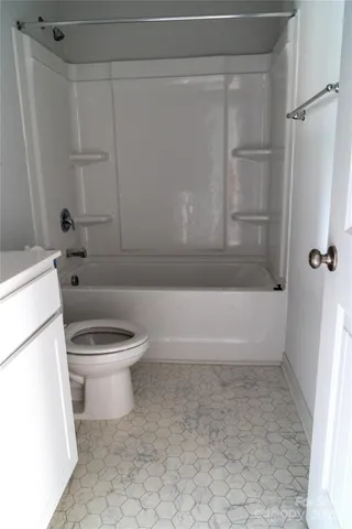 a white toilet sitting next to a bath tub