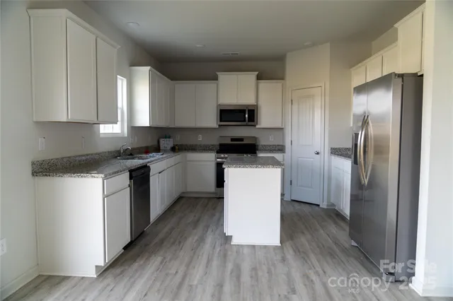 a kitchen with stainless steel appliances a refrigerator sink and cabinets