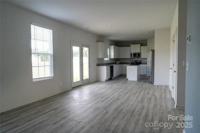 a kitchen with stainless steel appliances granite countertop a sink stove and wooden floor