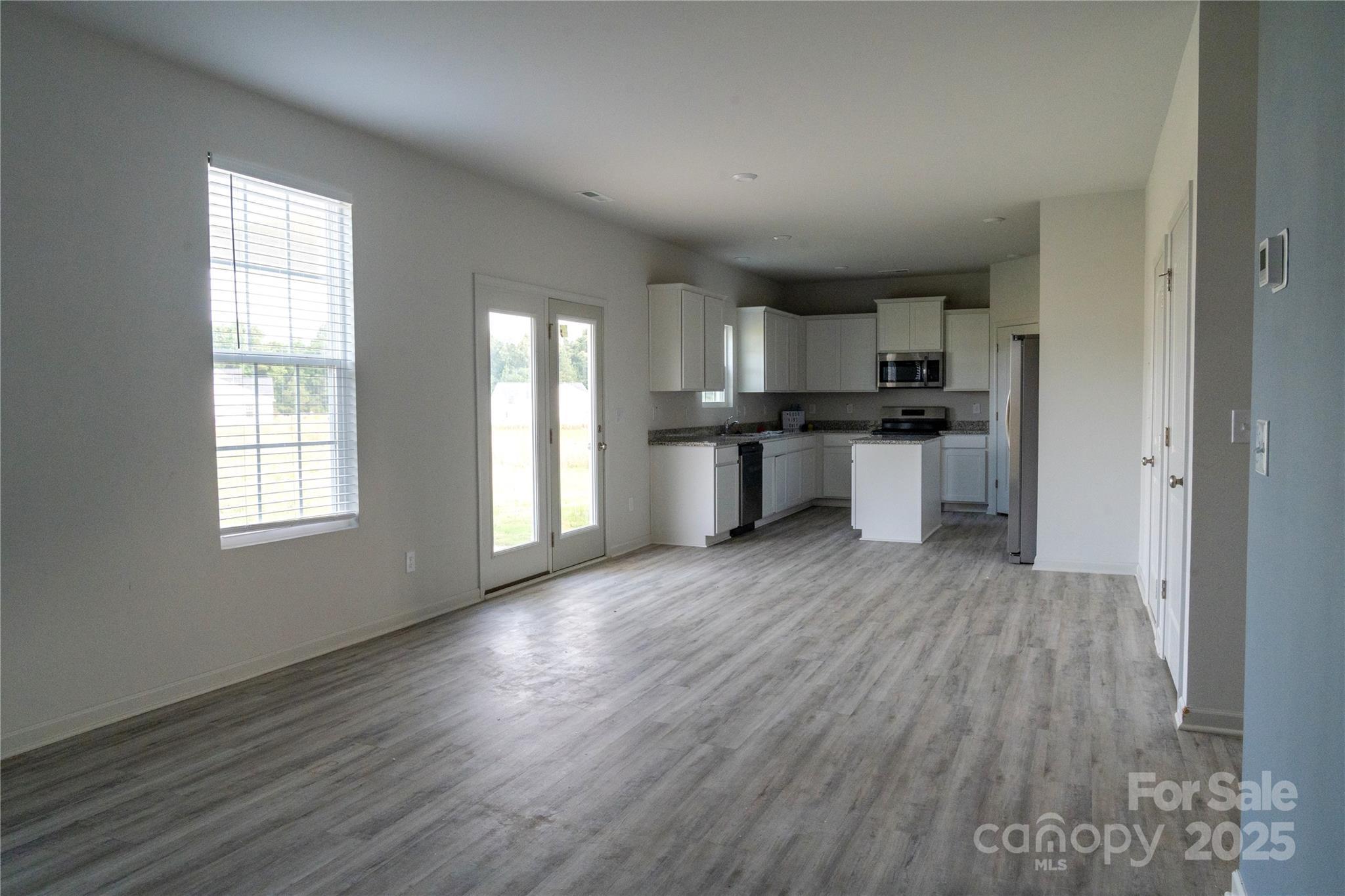 69 Ravibha Court Clayton, NC 27520 - Photo 4 of 16 a kitchen with stainless steel appliances granite countertop a sink stove and wooden floor