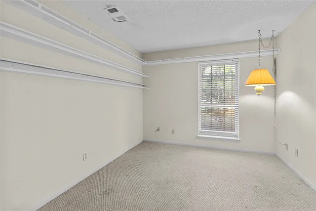 an empty room with a ceiling fan and a window