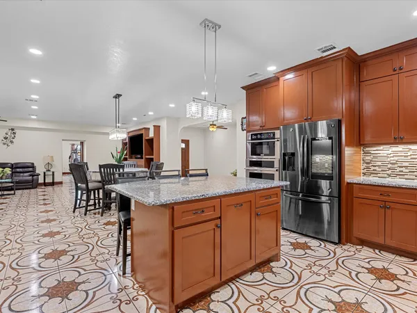 a kitchen with stainless steel appliances wooden cabinets a stove a sink and a window