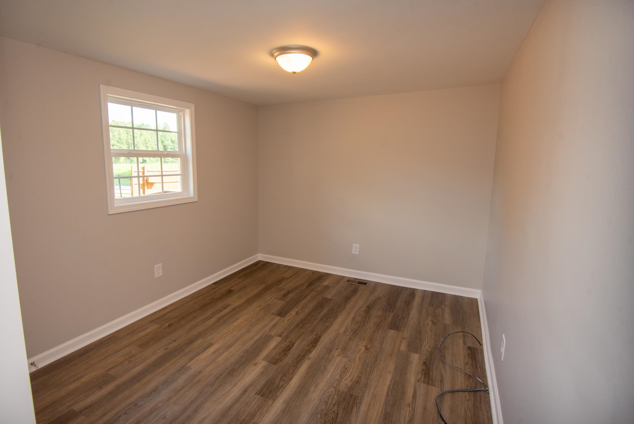 560 Covington Road Bunnlevel, NC 28323 - Photo 13 of 19 a view of an empty room with wooden floor and a window