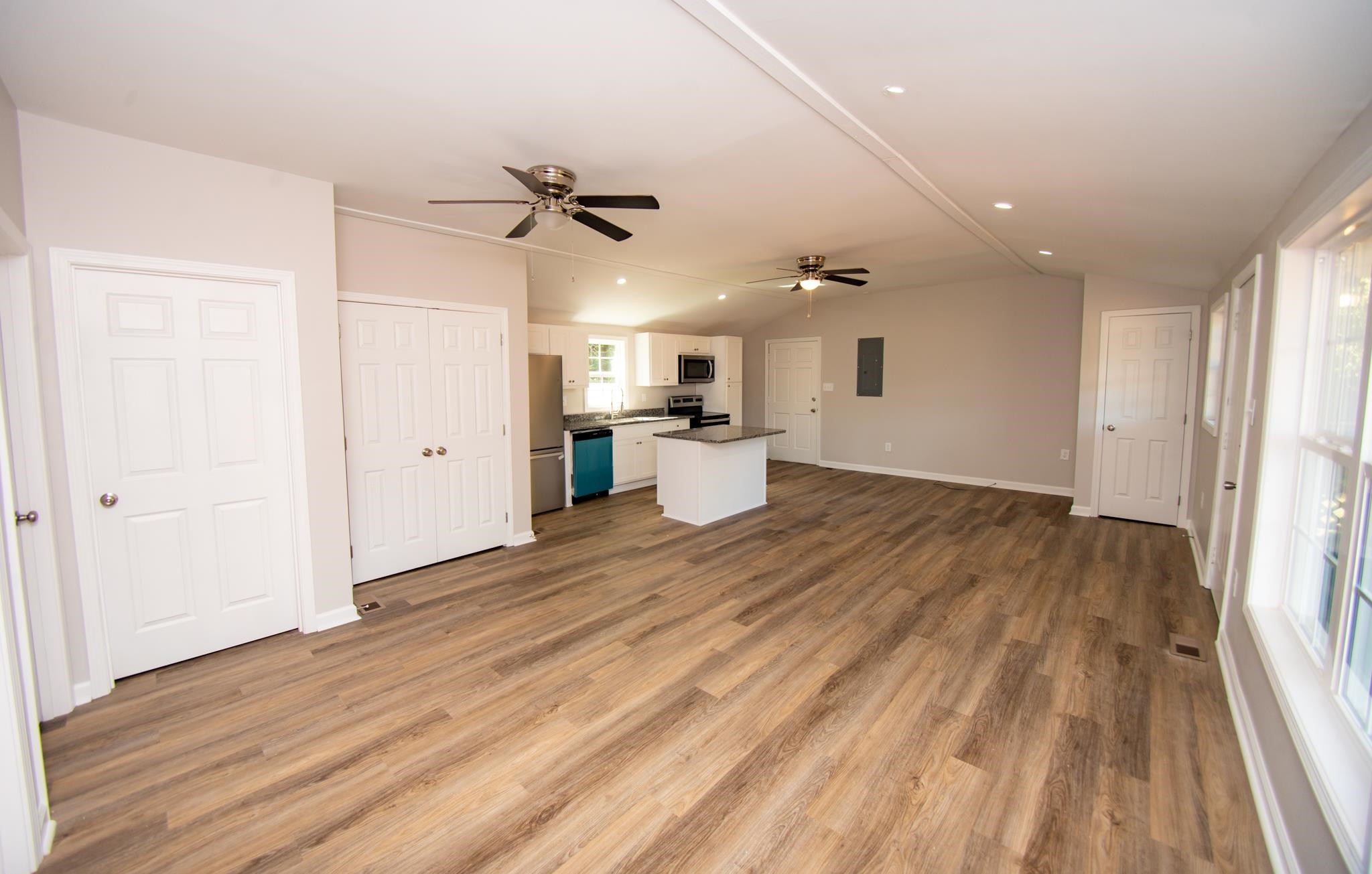 560 Covington Road Bunnlevel, NC 28323 - Photo 2 of 19 an empty room with wooden floor a ceiling fan and windows