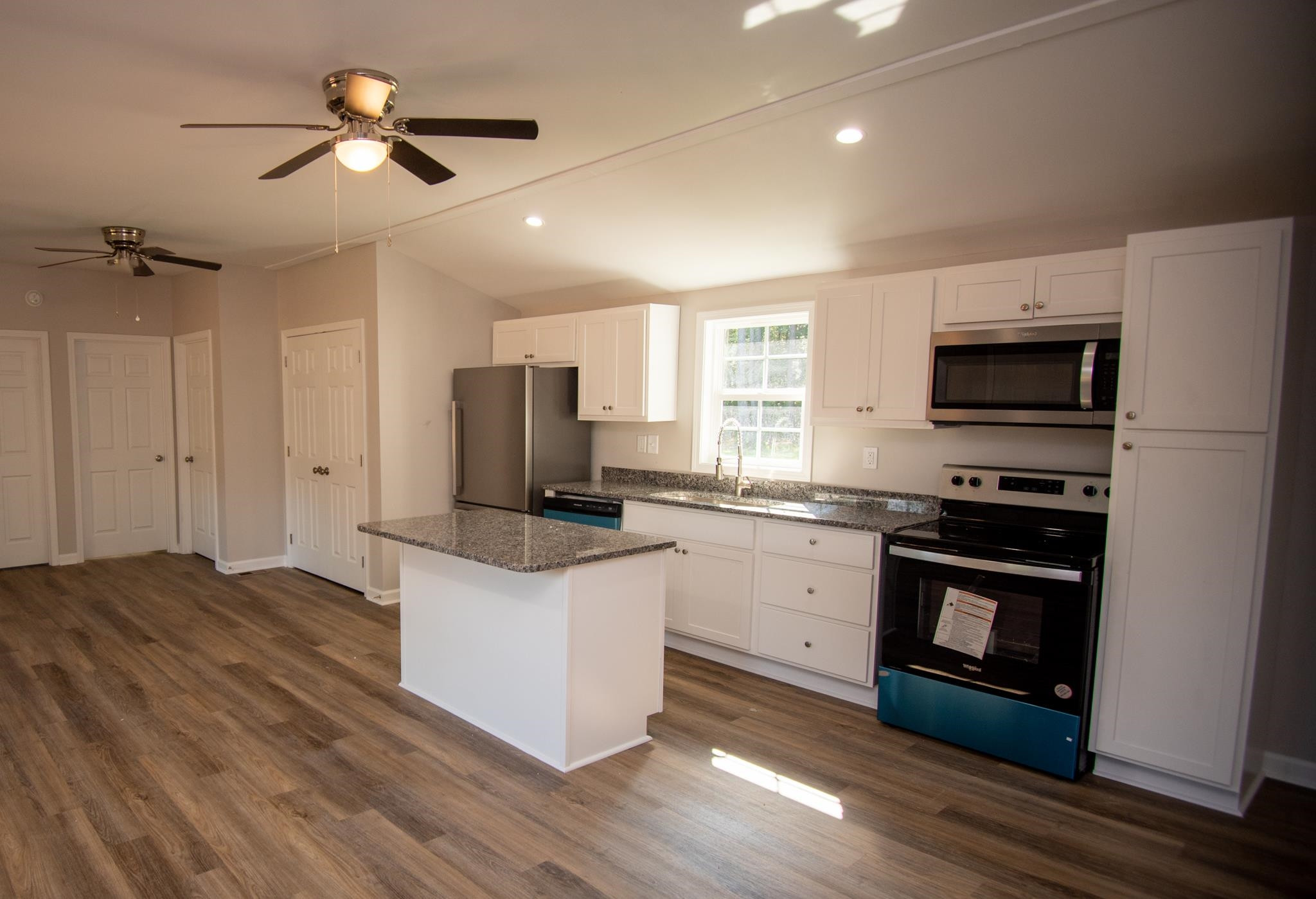 560 Covington Road Bunnlevel, NC 28323 - Photo 5 of 19 a kitchen with stainless steel appliances a stove top oven a refrigerator cabinets and wooden floor