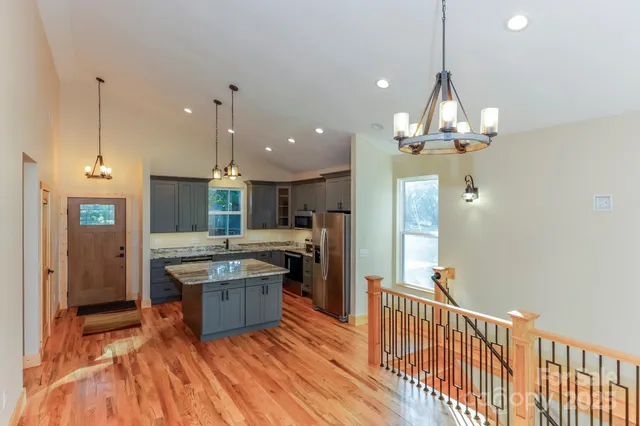 a kitchen with stainless steel appliances granite countertop a sink a stove and a refrigerator