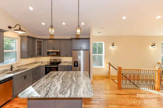a kitchen with stainless steel appliances granite countertop a sink stove and refrigerator
