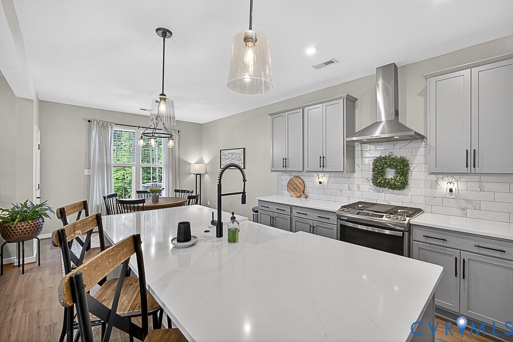 18517 Palisades Ridge Moseley, VA 23120 - Photo 8 of 55 a kitchen with stainless steel appliances granite countertop a stove a sink dishwasher a dining table and chairs with wooden floor