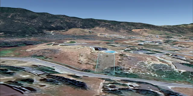 an aerial view of residential houses with outdoor space and trees