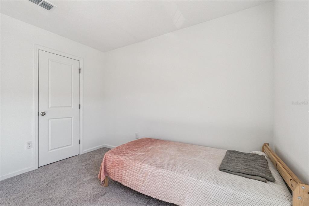 5931 Chestnut Grv Place St. Cloud, FL 34771 - Photo 13 of 20 a bedroom with a bed and a cabinets