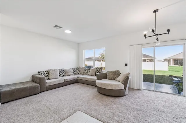 a living room with furniture and a floor to ceiling window
