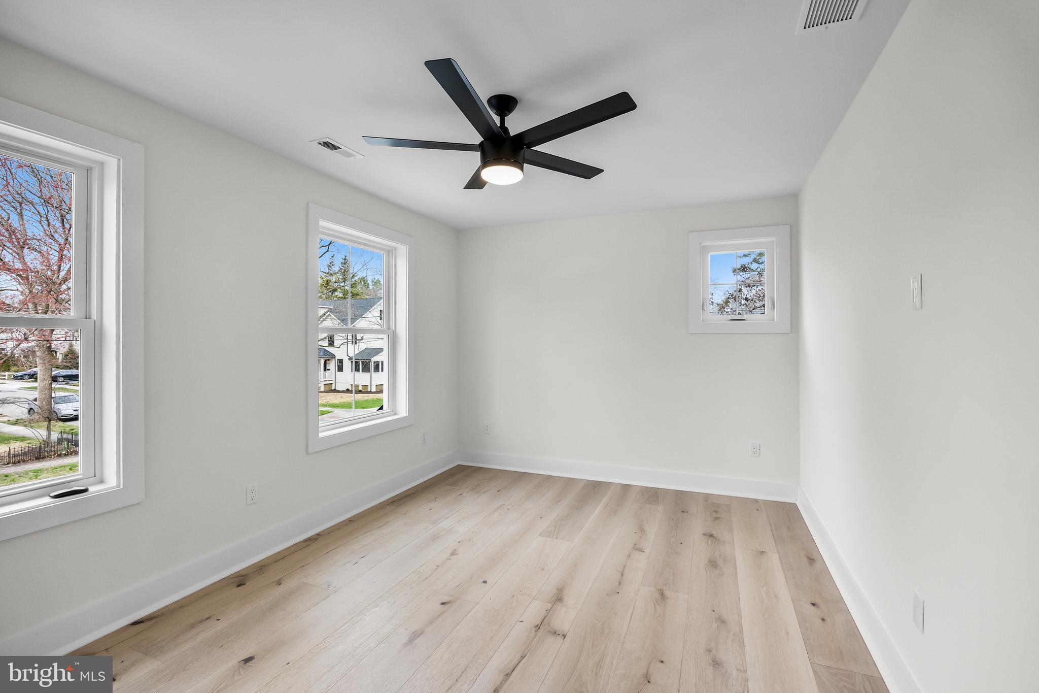 201 Centre Street Haddonfield, NJ 08033 - Photo 28 of 48 an empty room with wooden floor a ceiling fan and windows