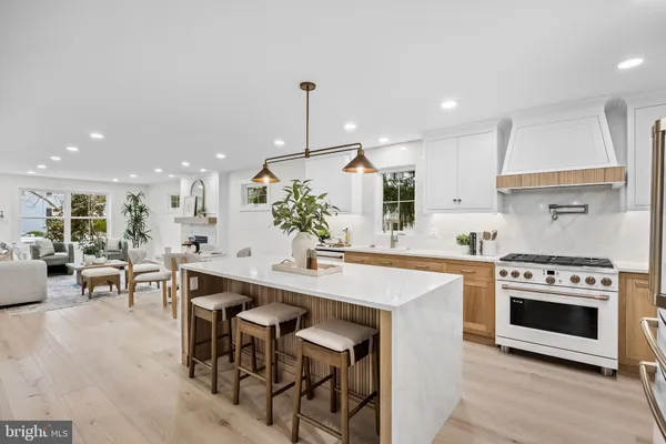 a kitchen with stainless steel appliances a stove a sink a oven a table and chairs