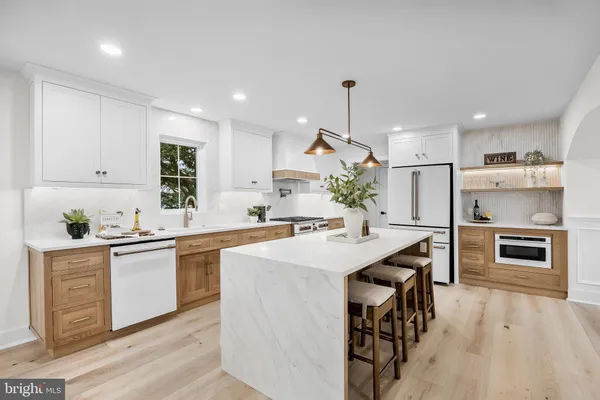 a kitchen with stainless steel appliances kitchen island a table and chairs in it