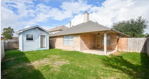 a view of a house with a yard and fence