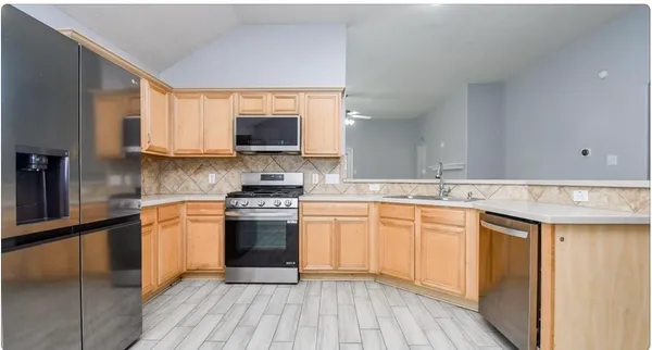 a kitchen with stainless steel appliances granite countertop a stove a sink and a microwave