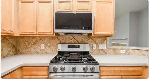 a kitchen with granite countertop a stove and a microwave