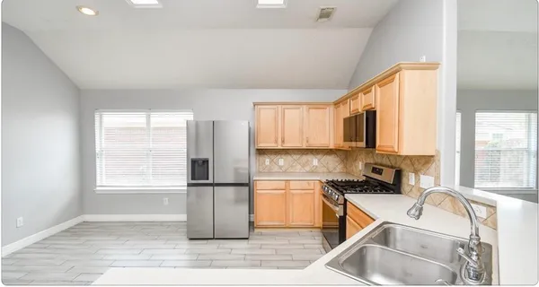 a kitchen with a sink a refrigerator and cabinets
