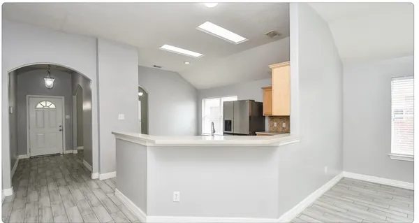 a view of a room with wooden floor and mirror