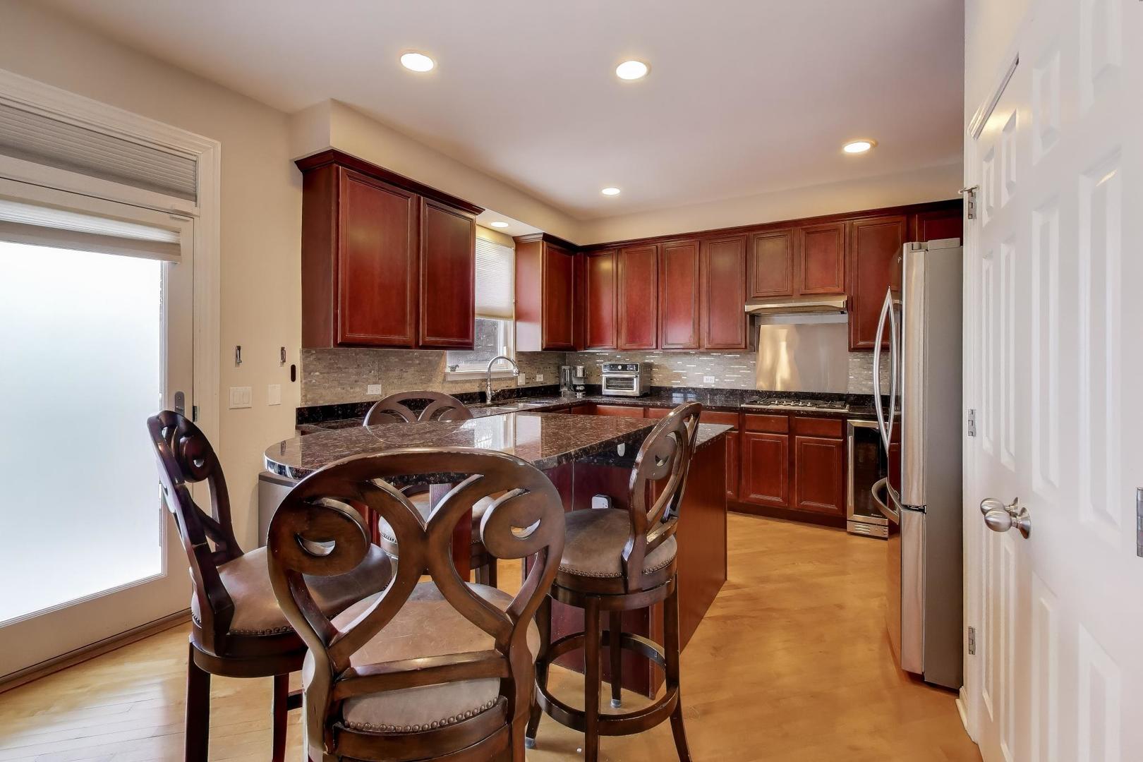 773 Sarah Lane Northbrook, IL 60062 - Photo 8 of 29 a kitchen with stainless steel appliances granite countertop a table chairs sink and cabinets