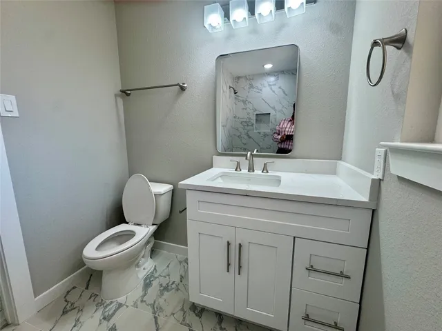 a bathroom with a sink toilet and mirror