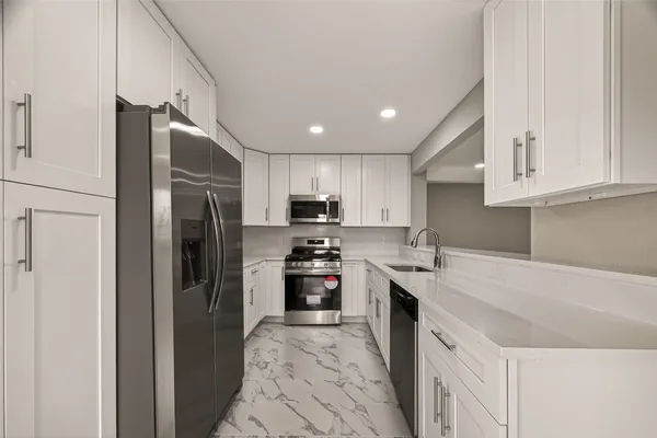 a kitchen with stainless steel appliances granite countertop a refrigerator sink and stove