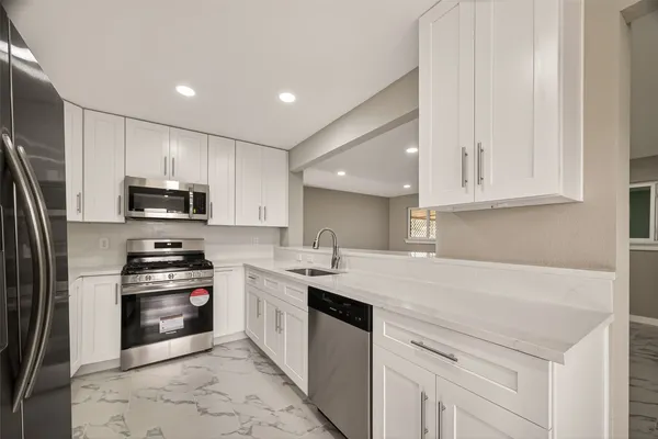 a kitchen with stainless steel appliances granite countertop a sink stove and refrigerator