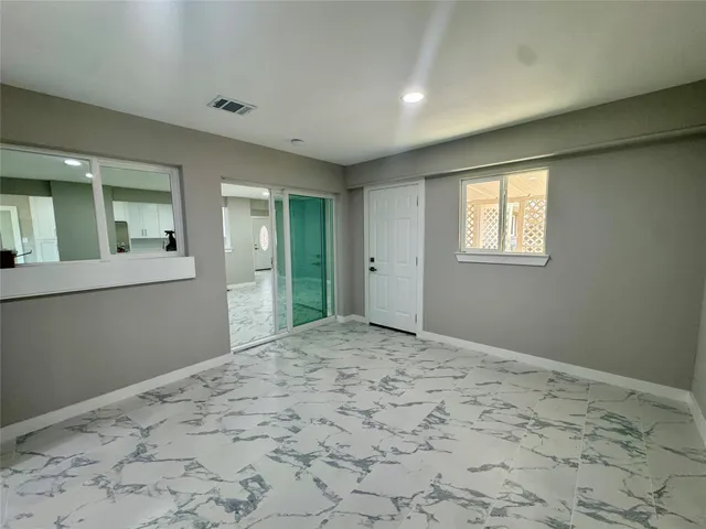 a view of a big room with wooden floor and windows
