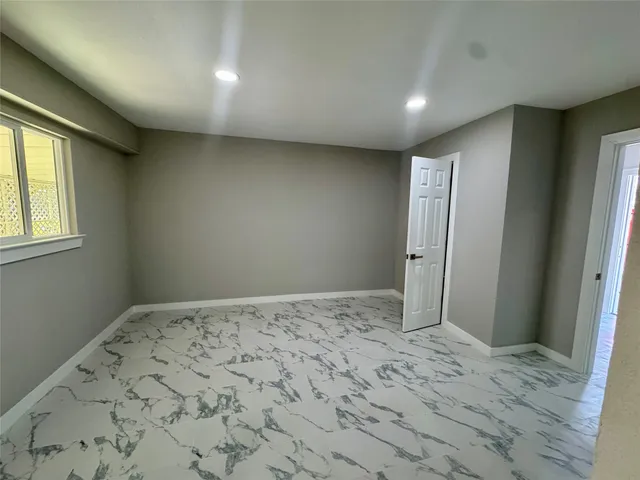 a view of a big room with wooden floor and windows
